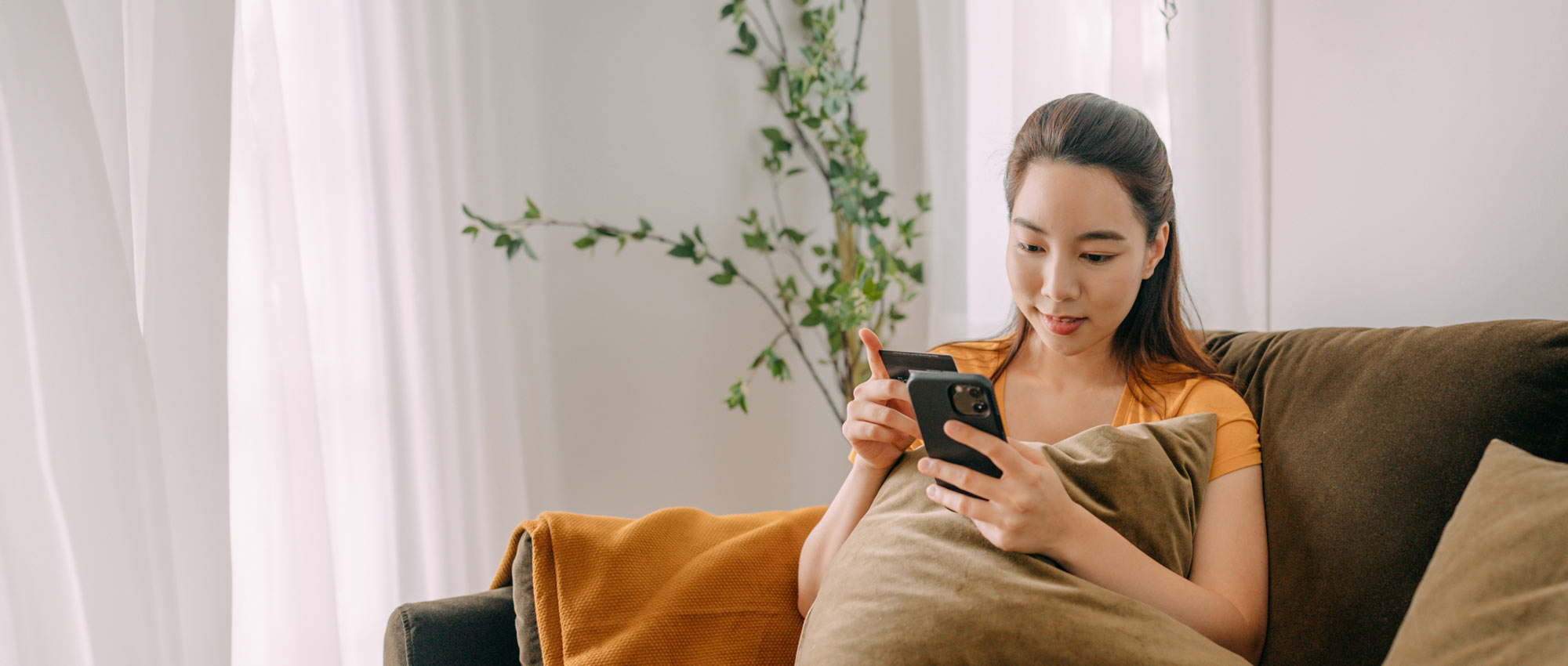 a woman is sitting at a table with a towel wrapped around her head and a little girl sitting on top of her while eating a sandwich and looking at a laptop computer